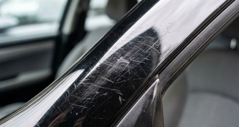 царапины на глянцевой стойке салона автомобиля крупным планом